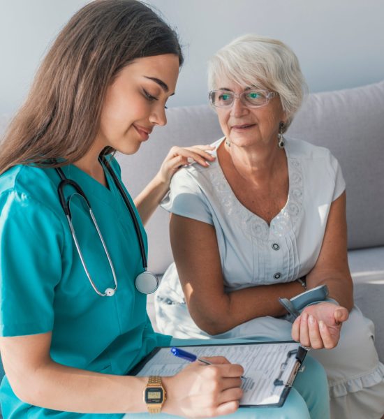 Nurse doing blood pressure monitoring for senior woman at home Nurse doing blood pressure monitoring for senior woman at home. Close up photo of blood pressure measurement. Nurse measuring blood pressure of senior woman at home. Smiling to each other.